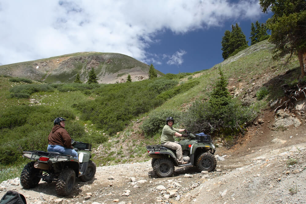 Two people on ATVs on a trail in Estes Park