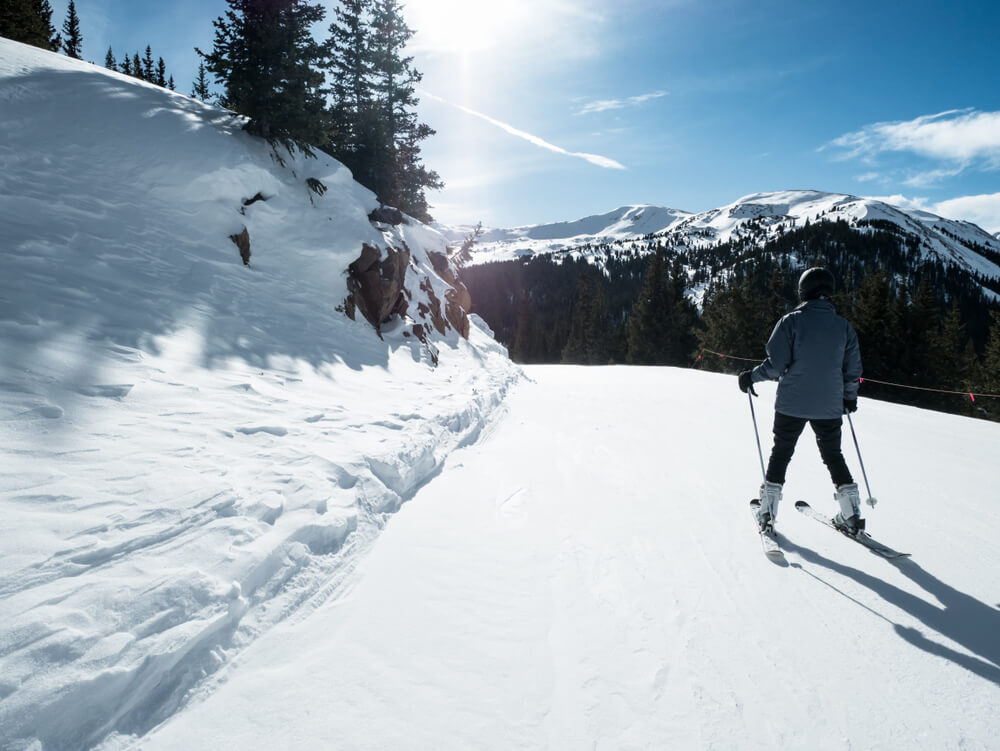 a man cross country skiing with a mountain view in snowy Estes Park