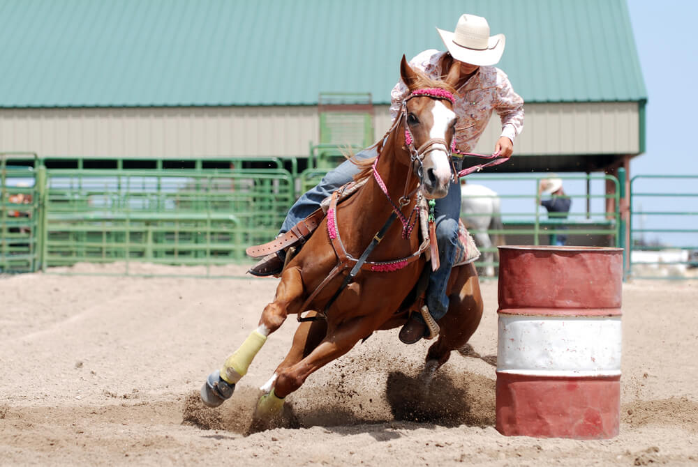 A cowgirl on horseback at a rodeo event in Estes Park