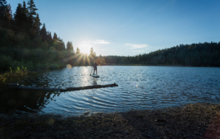 A man paddle boarding on a lake in Rocky Mountain National Park near Estes Park